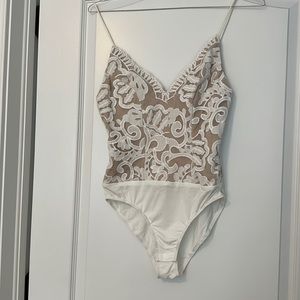 Skin tone with white appliqué bodysuit.